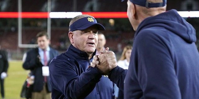 Nov. 27, 2021; Stanford, Kalifornië, VSA; Notre Dame Fighting Irish head coach Brian Kelly receives congratulations after the game against the Stanford Cardinal at Stanford Stadium.