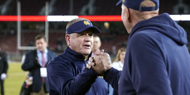 Nov 27, 2021; Stanford, California, USA; Notre Dame Fighting Irish head coach Brian Kelly receives congratulations after the game against the Stanford Cardinal at Stanford Stadium.