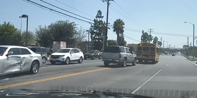 Police dashcam footage shows the driver of an SUV trying to ram a school bus.