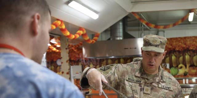 CAMP ARIFIJAN, Kuwait - Maj. Wes McCullough, the officer in charge of operations for the 3rd Division Sustainment Brigade, serve food at a dining facility on Camp Arifijan, Kuwait, Nov. 25, 2021. (U.S. Army photo by Sgt. Marquis Hopkins) 