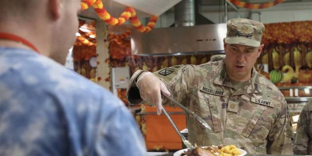 CAMP ARIFIJAN, Kuwait - Maj. Wes McCullough, the officer in charge of operations for the 3rd Division Sustainment Brigade, serve food at a dining facility on Camp Arifijan, Kuwait, Nov. 25, 2021. (U.S. Army photo by Sgt. Marquis Hopkins)