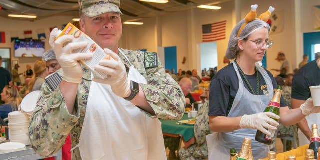 CAMP LEMONNIER, Djibouti - U.S. Navy Senior Chief Builder Sean Spence, left, and Chief Boatswain’s Mate Francis Morales, sailors currently deployed to Camp Lemonnier, Djibouti (CLDJ), serve a Thanksgiving meal to their fellow service members on Nov. 25, 2021. (U.S. Navy photo by Mass Communication Specialist 2nd Class Jonathan Word)