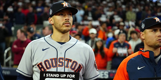 ATLANTA, GA - OCTOBER 30: Carlos Correa #1 of the Houston Astros holds up a Stand Up To Cancer placard at the end of the fifth inning of Game 4 of the 2021 World Series between the Houston Astros and the Atlanta Braves at Truist Park on Saturday, October 30, 2021 in Atlanta, Georgia.