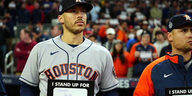 ATLANTA, GA - OCTOBER 30: Carlos Correa #1 of the Houston Astros holds up a Stand Up To Cancer placard at the end of the fifth inning of Game 4 of the 2021 World Series between the Houston Astros and the Atlanta Braves at Truist Park on Saturday, October 30, 2021 in Atlanta, Georgia.