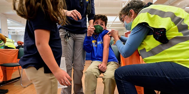 FILE PHOTO: A child reacts while receiving a dose of the Pfizer-BioNTech coronavirus disease (COVID-19) vaccine at Smoketown Family Wellness Center in Louisville, Kentucky, U.S., November 8, 2021. REUTERS/Jon Cherry/File Photo