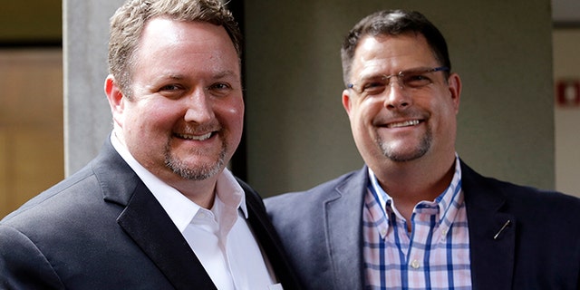 Curt Freed, left, and his partner Robert Ingersoll pose for a photo after a hearing before Washington's Supreme Court, Tuesday, Nov. 15, 2016, in Bellevue, Wash. The couple sued florist Barronelle Stutzman for refusing to provide services for their wedding and Stutzman she was exercising her First Amendment rights, but justices questioned whether ruling in her favor would mean other businesses could turn away customers based on racial or other grounds. (AP Photo/Elaine Thompson)