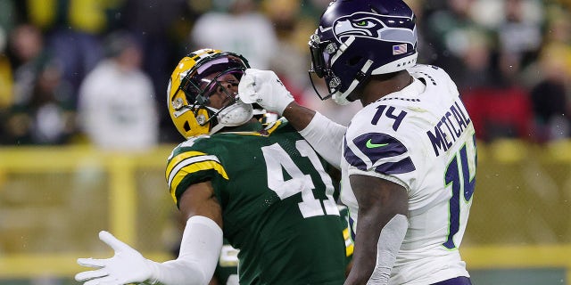 GREEN BAY, WISCONSIN - NOVEMBER 14: Henry Black #41 of the Green Bay Packers and DK Metcalf #14 of the Seattle Seahawks get into an altercation during the fourth quarter at Lambeau Field on November 14, 2021 in Green Bay, Wisconsin.