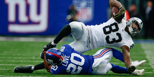 The New York Giants' Julian Love (20) tackles the Las Vegas Raiders' Darren Waller (83) during a game Nov. 7, 2021, a East Rutherford, N.J.