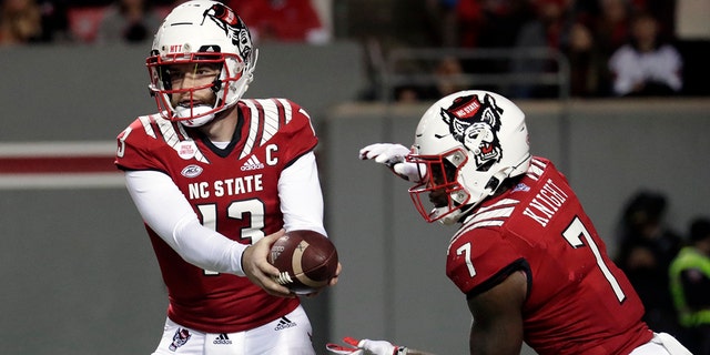 North Carolina State quarterback Devin Leary (13) hands off to running back Zonovan Knight (7) during the first half of the team's NCAA college football game against North Carolina on Friday, Nov. 26, 2021, in Raleigh, North Carolina.