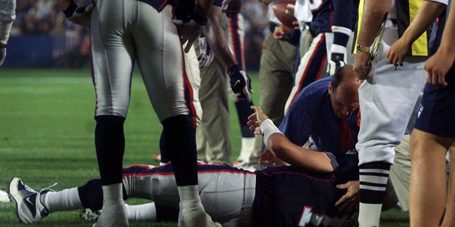 Patriots quarterback Drew Bledsoe is attended to by team doctor Bert Zarins after being hit in the fourth quarter on Sept. 23, 2001, a Foxborough, Massachusetts.