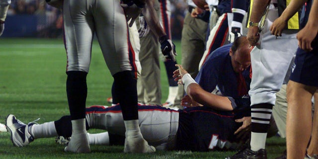 Patriots quarterback Drew Bledsoe is attended to by team doctor Bert Zarins after being hit in the fourth quarter.