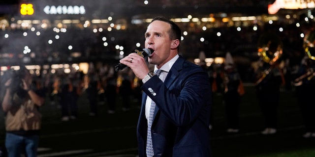 Former New Orleans Saints quarterback Drew Brees leads a crowd cheer as he is honored during a ceremony at halftime of an NFL football game between the New Orleans Saints and the Buffalo Bills in New Orleans, Thursday, Nov. 25, 2021.
