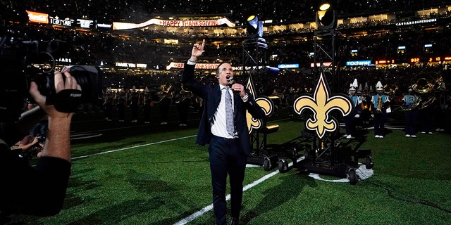 L'ancien quart-arrière des New Orleans Saints Drew Bryce mène les acclamations de la foule alors qu'il est honoré lors d'un match de football de première mi-temps entre les New Orleans Saints et les Buffalo Bills à la Nouvelle-Orléans, le jeudi 25 novembre 2021.