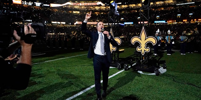 Former New Orleans Saints quarterback Drew Brees leads a crowd cheer as he is honored during a ceremony at halftime of an NFL football game between the New Orleans Saints and the Buffalo Bills in New Orleans, Thursday, Nov. 25, 2021.