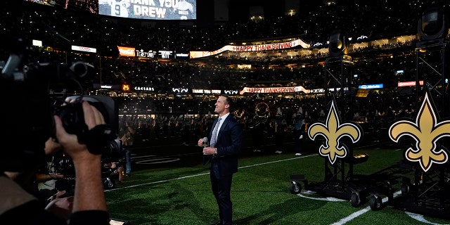 Former New Orleans Saints quarterback Drew Brees acknowledges the crowd as he is honored during a ceremony at halftime of an NFL football game between the New Orleans Saints and the Buffalo Bills in New Orleans, Thursday, Nov. 25, 2021.
