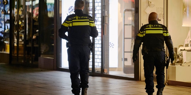 Police officers walk along an empty shopping street as The Netherlands implements new measures of a soft evening lockdown to counter the Coronavirus pandemic on November 28, 2021 in Rotterdam, Netherlands. (Photo by Pierre Crom/Getty Images)