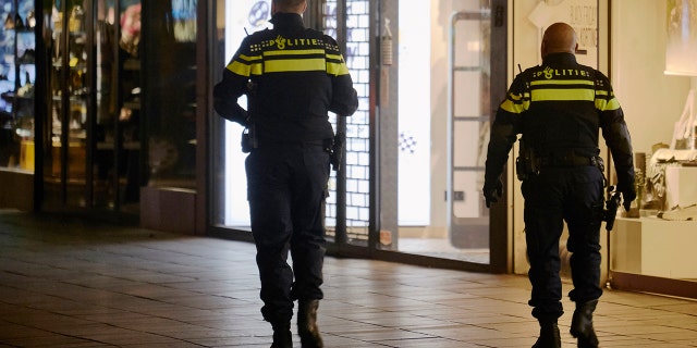 Police officers walk along an empty shopping street as The Netherlands implements new measures of a soft evening lockdown to counter the Coronavirus pandemic on November 28, 2021 in Rotterdam, Netherlands. (Photo by Pierre Crom/Getty Images)