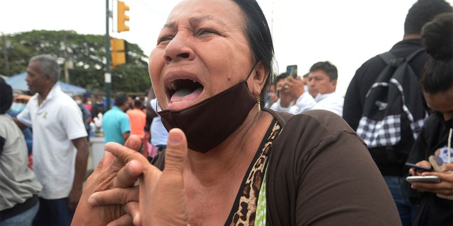 A relative of an inmate in the Litoral penitentiary demands for information about the fate the morning after riots broke out inside the jail in Guayaquil, Ecuador, Saturday, Nov. 13, 2021. 