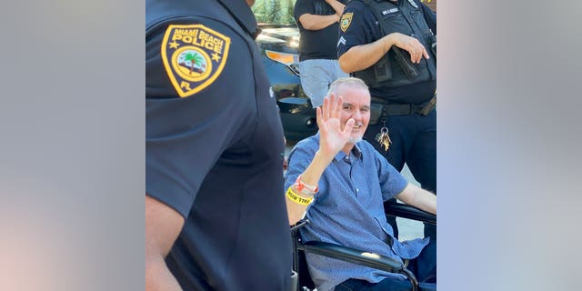 Miami Beach Police Officer JC Sampedro waves after being discharged from the Broward Health North facility on Monday, Nov. 15, 2021. Photo Credit: Twitter @MiamiBeachPD