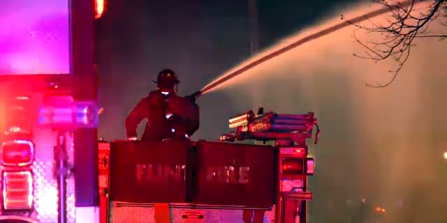 A Flint firefighter direct a hose toward a blaze, Nov. 22, 2021. (FOX 66)