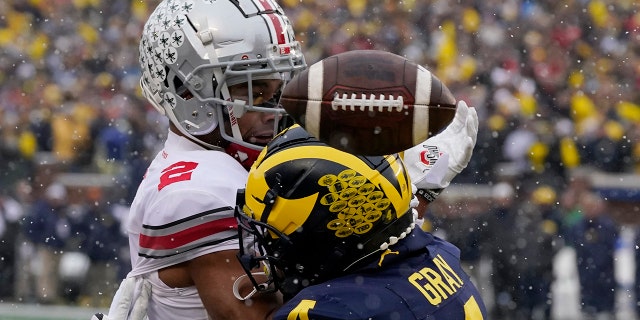 Michigan defensive back Vincent Gray (4) breaks up a pass intended for Ohio State wide receiver Chris Olave (2) during the first half of an NCAA college football game, 土曜日, 11月. 27, 2021, in Ann Arbor, 私.