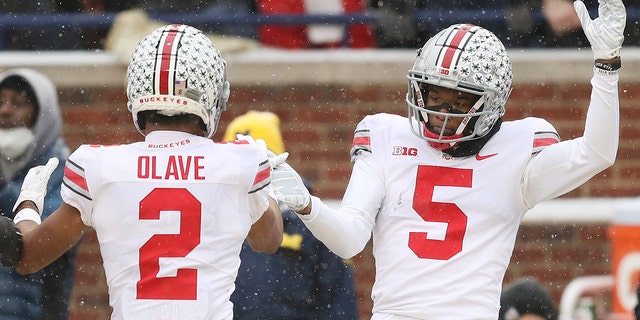 ANN ARBOR, 密歇根州 - 十一月 27: Garrett Wilson #5 of the Ohio State Buckeyes celebrates his touchdown against the Michigan Wolverines with teammate Chris Olave #2 during the second quarter at Michigan Stadium on November 27, 2021 in Ann Arbor, 密西根州.