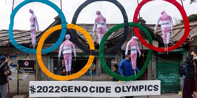 In this February 3, 2021 file photo, Tibetans in exile use the Olympic rings as a prop as they stage a street protest against the holding of the Beijing 2022 Winter Olympics in Dharmsala, India.