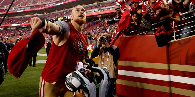 George Kittle of the San Francisco 49ers looks to toss his hat to a fan after the game against the Minnesota Vikings on Nov. 28, 2021, in Santa Clara, California.
