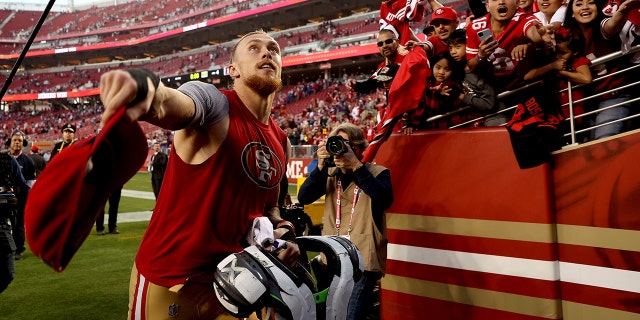 George Kittle of the San Francisco 49ers looks to toss his hat to a fan after the game against the Minnesota Vikings on Nov. 28, 2021, in Santa Clara, California.