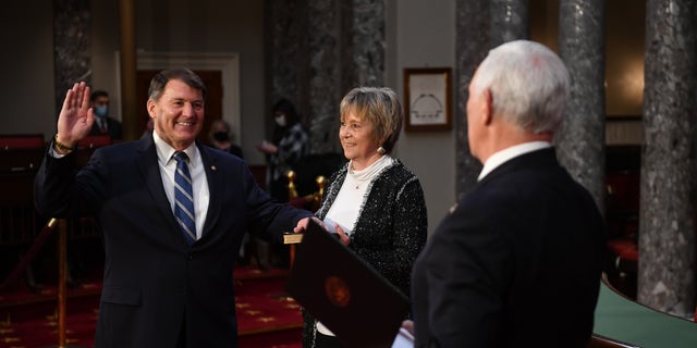 Senator Mike Rounds, RS.D., participates in a false oath to the 117th Congress with Vice President Mike Pence as his wife Jean Rounds holds a Bible, in the old Senate chamber of the US Capitol in Washington, DC on January 3, 2021. (Photo by KEVIN DIETSCH / AFP via Getty Images)