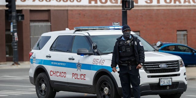 A Chicago Police officer monitors the scene after a shooting in Chicago, Illinois, on March 14, 2021. (Kamil Krzaczynski / AFP via Getty Images)