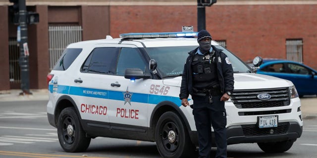 A Chicago police officer monitors the scene after a shooting on March 14, 2021.