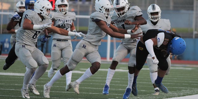 LOS ANGELES, CA - APRIL 9, 2021: Five Reseda defenders team up to force Crenshaw wide receiver Centrell Wise (10) out of bounds in the first half at Crenshaw High School on April 9, 2021 in Los Angeles, California.(Gina Ferazzi / Los Angeles Times via Getty Images)