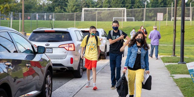 Alunos mascarados chegam ao primeiro dia de aula na Glasgow Middle School em Lincolnia, Virgínia, na segunda-feira, 23 de agosto de 2021, o primeiro dia de volta às aulas do distrito escolar do condado de Fairfax. (Amanda Andrade-Rhoades/Para o Washington Post via Getty Images)