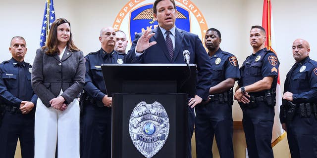 LAKELAND, FLORIDA, UNITED STATES - 2021/09/07: Florida Attorney General Ashley Moody ( second left) looks on as Governor Ron DeSantis speaks at a press conference at the Lakeland, Florida Police Department to announce a new proposal that would provide $5,000 signing bonuses to those who sign on to be law enforcement officers from within the state of Florida, and those who come from out-of-state.