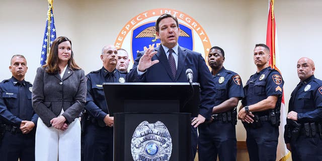 LAKELAND, FLORIDA, UNITED STATES - 2021/09/07: Florida Attorney General Ashley Moody ( second left) looks on as Governor Ron DeSantis speaks at a press conference at the Lakeland, Florida Police Department to announce a new proposal that would provide $5,000 signing bonuses to those who sign on to be law enforcement officers from within the state of Florida, and those who come from out-of-state.