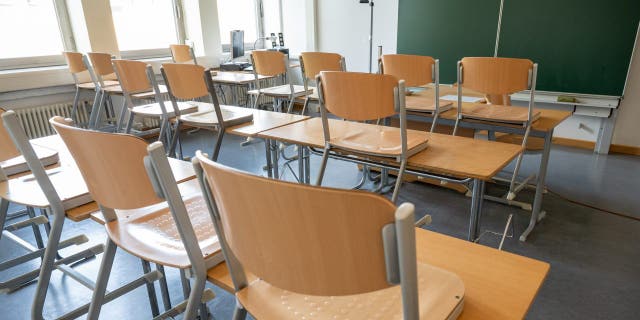 An empty classroom with the chairs up.