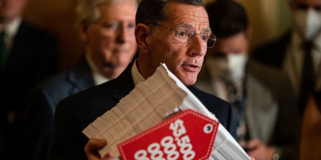 Sen. John Barrasso holds a copy of the reconciliation bill at the U.S. Capitol on Sept. 28, 2021.  (Kent Nishimura / Los Angeles Times via Getty Images)
