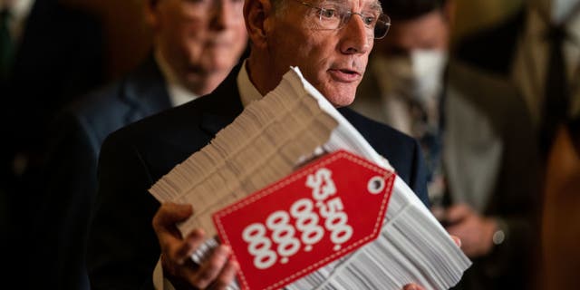 Sen. John Barrasso holds a copy of the reconciliation bill at the U.S. Capitol on Sept. 28, 2021.  (Kent Nishimura / Los Angeles Times via Getty Images)