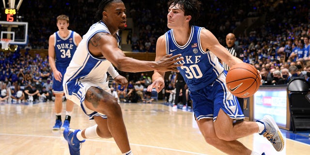 15: Michael Savarino #30 of the Duke Blue Devils drives against Trevor Keels #1 during Countdown To Craziness at Cameron Indoor Stadium on October 15, 2021 in Durham, North Carolina.