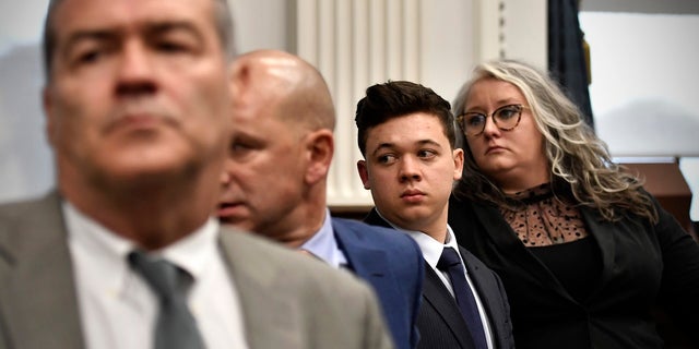 Kyle Rittenhouse, third from left, stands with his legal team, from left, Mark Richards, Corey Chirafisi and Natalie Wisco as the jury leaves the room for the day at the Kenosha County Courthouse on November 5, 2021 in Kenosha, Wisconsin. (Photo by Sean Krajacic - Pool/Getty Images)