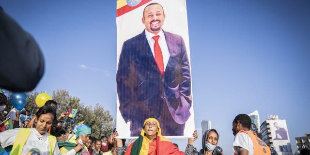 A woman holds up a banner of Ethiopian Prime minister Abiy Ahmed as a ceremony is held to support the Ethiopian military troops who is battling against the Tigrays People Liberation Front in Amhara Region on Nov. 7, 2021 in Addis Ababa, Ethiopia.