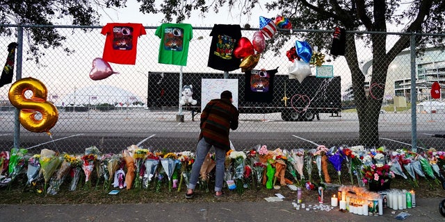A visitor writes a note at a memorial outside the canceled Astroworld Festival at NRG Park on November 7, 2021 in Houston. 