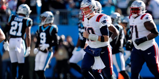 Charlotte, NC - November 7: New England Patriots quarterback Mac Jones (10) heads off the field as Panthers CB Stephon Gilmore (9) celebrates after he intercepted a third quarter pass from Jones. The New England Patriots visited the Carolina Panthers for a regular season NFL football game at Bank of America Stadium in Charlotte, NC on Nov. 7, 2021.