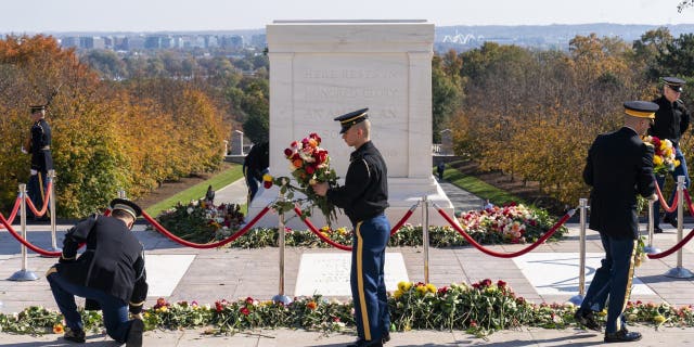 Soldiers with the 3rd U.S. Infantry Regiment, known as "The Old Guard," move flowers during a centennial commemoration event at the Tomb of the Unknown Soldier in Arlington National Cemetery on Nov. 10, 2021.