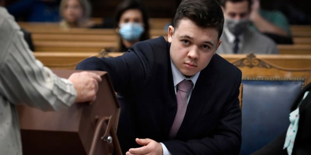 Kyle Rittenhouse pulls numbers of jurors out of a tumbler during his trial at the Kenosha County Courthouse. (Photo by Sean Krajacic-Pool/Getty Images)