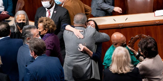 Rep. Alexandria Ocasio-Cortez embraces a fellow House Democrat after the vote Friday, Nov. 19, 2021, at the U.S. Capitol in Washington, D.C. (Stefani Reynolds/Bloomberg via Getty Images)