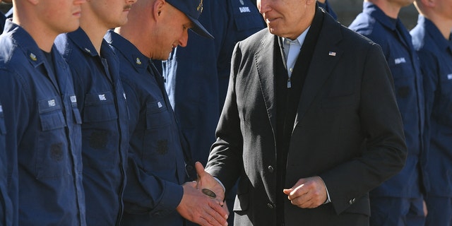 President Biden hands a service member a challenge coin as he greets members of the Coast Guard at U.S. Coast Guard Station Brant Point. (Photo by MANDEL NGAN/AFP via Getty Images)