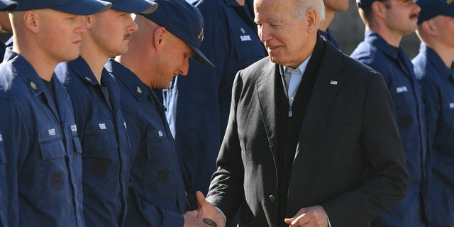 President Biden hands a service member a challenge coin as he greets members of the Coast Guard at U.S. Coast Guard Station Brant Point. (Photo by MANDEL NGAN/AFP via Getty Images)