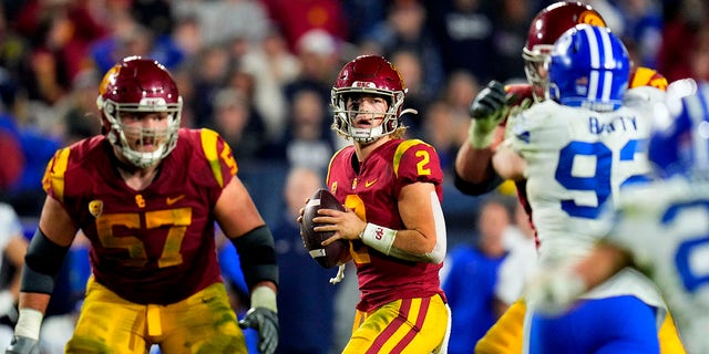 El mariscal de campo Jaxson Dart # 2 de los USC Trojans pasa contra los Brigham Young Cougars en la segunda mitad de un partido de fútbol de la NCAA en el Los Angeles Memorial Coliseum en Los Ángeles el sábado 27 de noviembre de 2021.